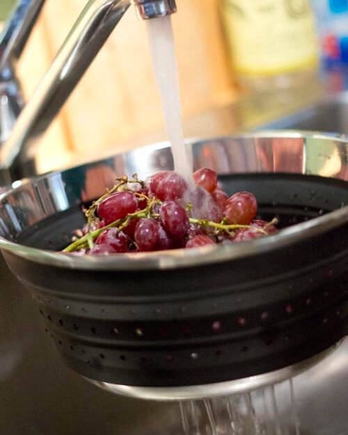 Kitchen colander filled with grapes