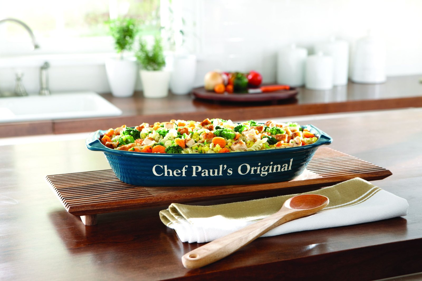 Ceramic baking dish with wooden spoon on a kitchen counter